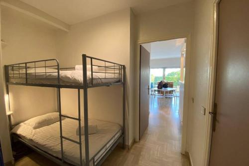 Cette chambre comprend 2 lits superposés dans un couloir. dans l'établissement C037-Nice studio with garden and parking - Near beach, à Cannes