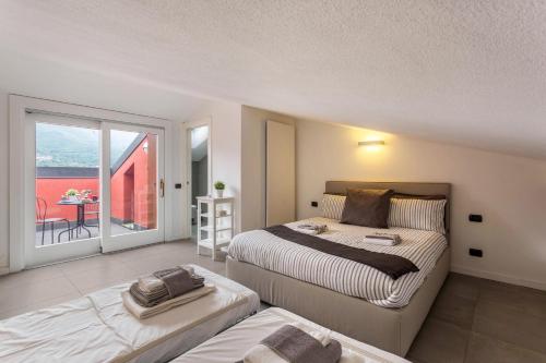 1 dormitorio con 2 camas y balcón en New Eleven Apartment on Como Lake, en Oliveto Lario