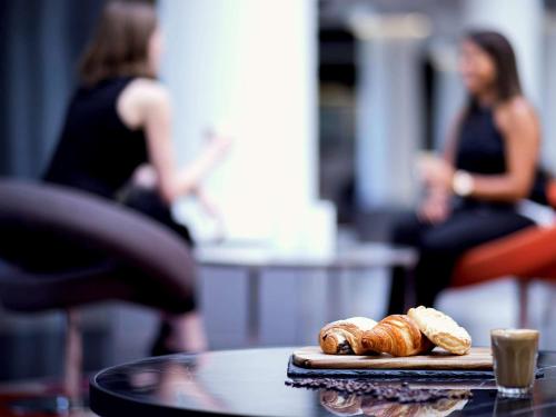 a table with two loaves of bread on a cutting board at Mercure Melbourne Albert Park in Melbourne