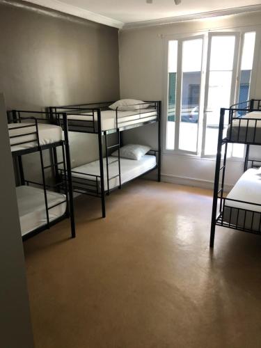 a room with four bunk beds and a window at La Promenade House in Nice