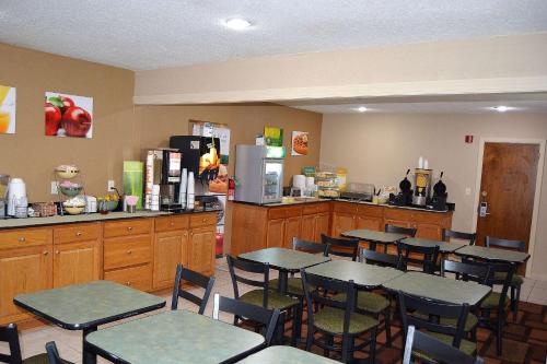 a kitchen filled with lots of tables and chairs at Quality Inn Raynham - Taunton in Raynham
