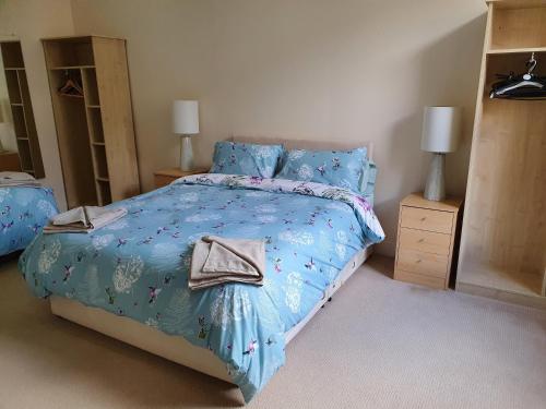 a bedroom with a bed with a blue comforter at Flat 1 Castlebank house Flats in Dingwall