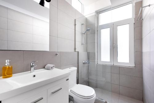 a white bathroom with a toilet and a sink at Supreme B2 Apartment in Syntagma in Athens