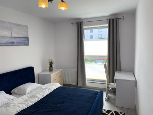 um quarto com uma cama azul e uma janela em Best Offer in Oldtown Gdansk em Gdansk
