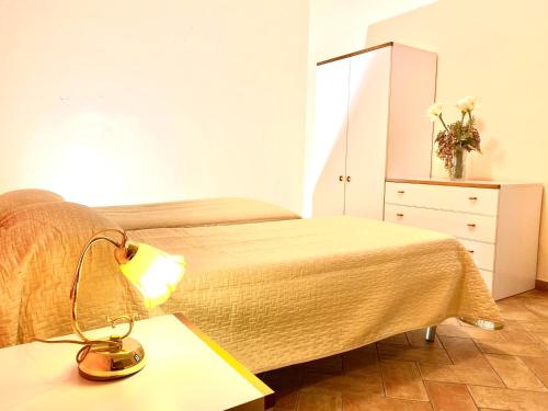 a bedroom with a bed and a desk with a lamp at Agriturismo L'Antica Quercia in Pomarance