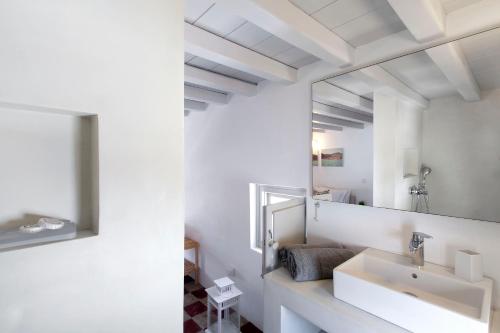a white bathroom with a sink and a mirror at Josephine Mykonos Town Villa - 1882 in Mýkonos City