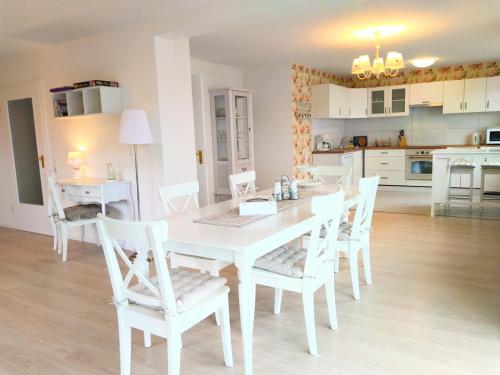 a white dining room with a white table and chairs at Romantic Style Apartment Titisee-Neustadt in Titisee-Neustadt