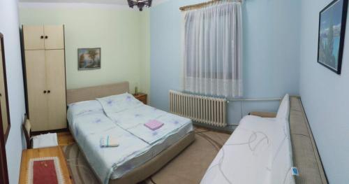 1 dormitorio con 2 camas y ventana en Prenoćište Dika, en Višegrad