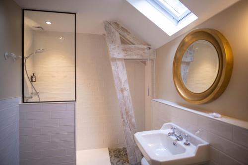 a bathroom with a sink and a shower and a mirror at Les Demeures de Varennes, BW Signature Collection in Varennes-Jarcy