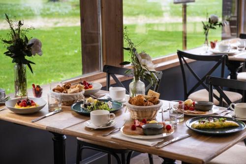 a wooden table with plates of food on it at Les Demeures de Varennes, BW Signature Collection in Varennes-Jarcy