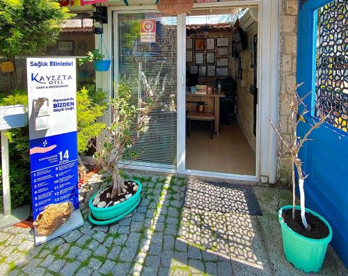 a front door of a house with two potted trees at Alacati Kayezta Hotel in Alacati