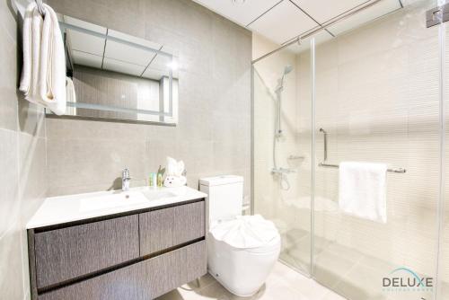 a bathroom with a toilet and a glass shower at Stylish 2BR in Bella Rose Al Barsha South by Deluxe Holiday Homes in Dubai