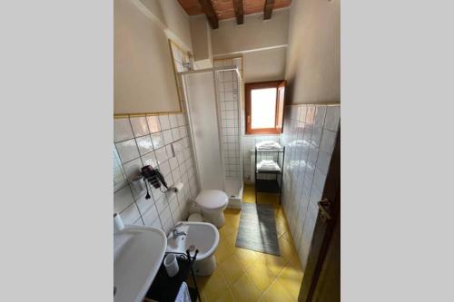 łazienka z 2 umywalkami i toaletą w obiekcie Casa Vacanze nel cuore della Toscana w mieście Castagno