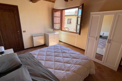 um quarto com uma cama grande e uma janela em Casa Vacanze nel cuore della Toscana em Castagno