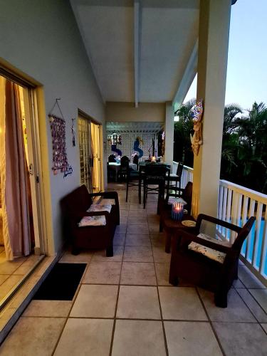 a living room with couches and a table on a porch at Ruby Sands Exclusive Holiday home in Ballito