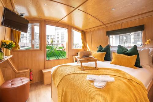 een slaapkamer met een bed met een laptop erop bij The Four Sisters Boatel - Houseboat in Edinburgh