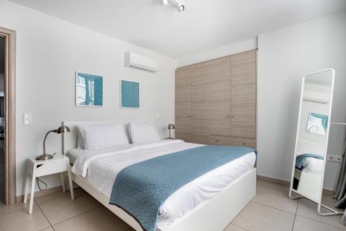 ein weißes Schlafzimmer mit einem großen Bett und einer blauen Decke in der Unterkunft Supreme D1 Penthouse 131m² in Syntagma in Athen