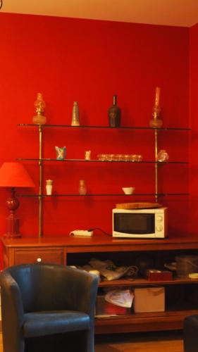 Cette chambre est dotée d'un mur rouge et d'un four micro-ondes. dans l'établissement La Garenne de Morestel, à Morestel