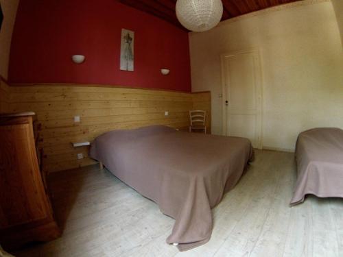 a bedroom with two beds in a room with red walls at Ensemble de 3 villas avec piscine chauffée, esprit détente in Sanguinet