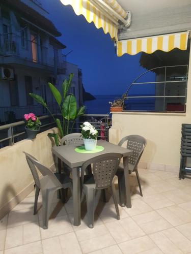 un tavolo e sedie su un patio con vista sull'oceano di Casa vacanze Aci Trezza ad Aci Castello