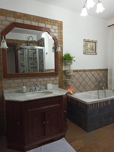 a bathroom with a tub and a sink and a mirror at Giardino di Circe in Agrigento