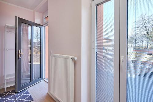 a hallway with a large glass door to a balcony at Schwalehof Gästewohnungen in Bönebüttel