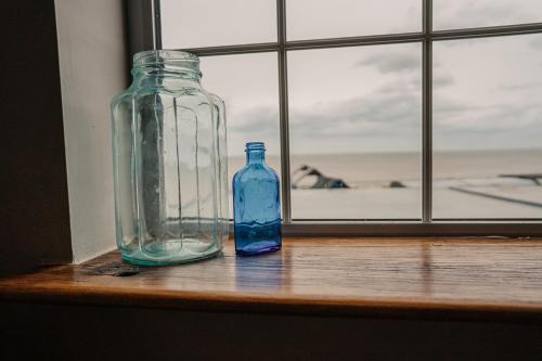 two glass bottles sitting on a window sill at The Ship Inn in Mundesley