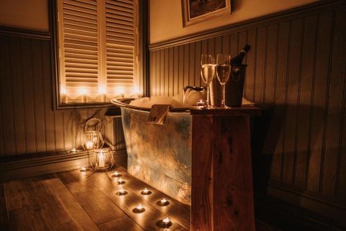 a bathroom with a tub with lights and a bottle of wine at The Ship Inn in Mundesley