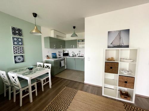 a kitchen and dining room with a table and chairs at Vízpart Honvéd Apartman in Balatonlelle
