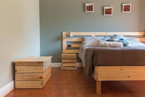 a bedroom with a bed and some wooden boxes at Albergo La Genzianella in Miasino