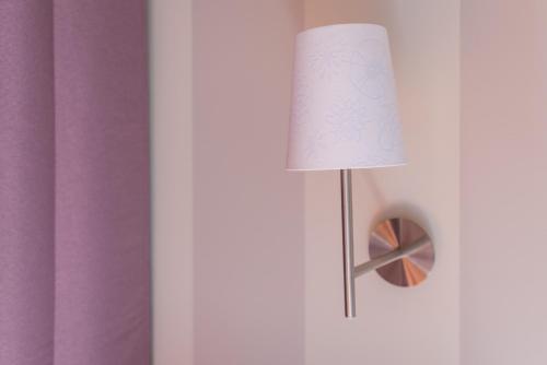 a lamp in a room with a purple wall at Albergo La Genzianella in Miasino