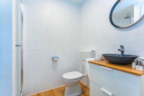 uma casa de banho com um lavatório, um WC e um espelho. em Sonnberg Lodge em Maria Alm am Steinernen Meer
