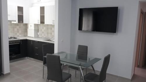 a kitchen with a table with chairs and a television on a wall at CASA ROXANA in Slatina