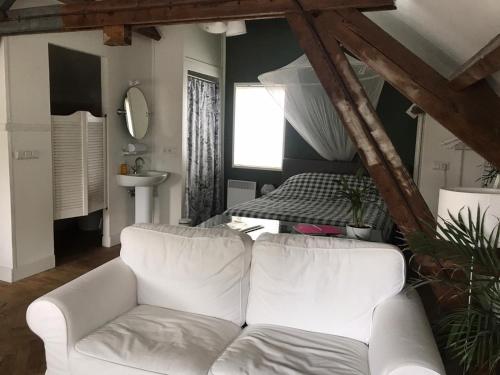a living room with a white couch and a bed at B&B In de Oude Smederij Zaltbommel in Zaltbommel