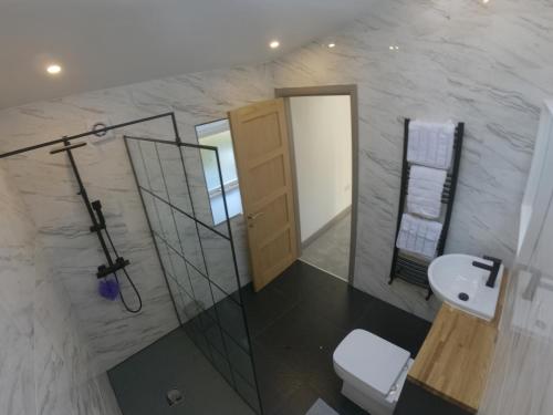 a bathroom with a shower and a toilet and a sink at Unique Barn conversion in Saddleworth in Oldham