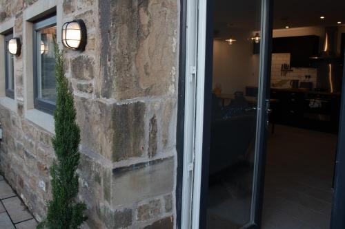 a brick wall with a light on the side of a building at Unique Barn conversion in Saddleworth in Oldham
