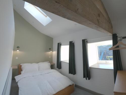 a bedroom with a bed with white sheets and a window at Unique Barn conversion in Saddleworth in Oldham