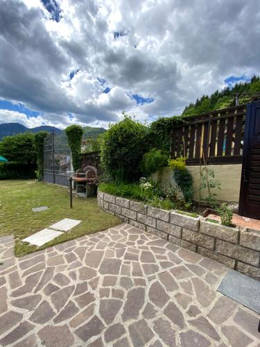 a backyard with a stone walkway and a fence at Casa Nina in Mezzolago