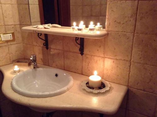 a bathroom with a sink with a candle on it at B&B DIMORA PALMIERI in Monopoli