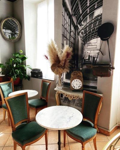 a room with two tables and chairs and a clock at Interlaken in Nice