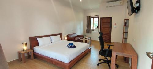 a bedroom with a bed and a desk and a desk at Le Grand Bleu Hotel in Wok Tum