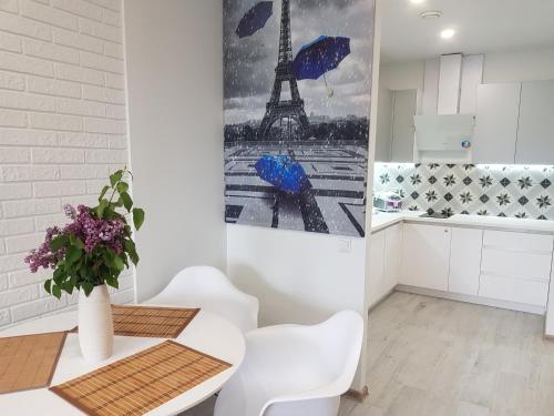 a kitchen with a table and a picture of the eiffel tower at Sunrise Arcadia Sky in Odesa