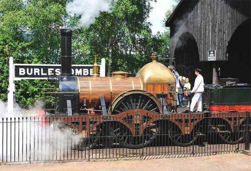 an old train sitting on the tracks next to a building at Didcot- Private Flat with Garden & Parking 03 in Didcot