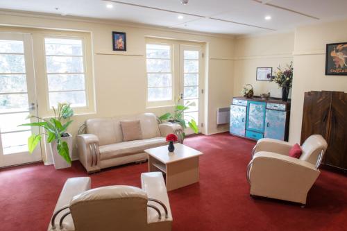 a living room with chairs and a couch and a table at Linaker Art Deco Motel in Beechworth