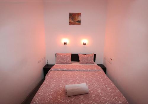 a bedroom with two beds with pink walls at Welcome Guest House in Lisbon