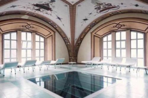 Cette chambre dispose d'une piscine avec des chaises et des fenêtres. dans l'établissement T2 Bis, calme, plein centre de Luchon, avec balcon et garage, à Luchon