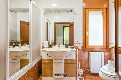 a bathroom with two sinks and a toilet at Alcam Can Macia in Corbera de Llobregat