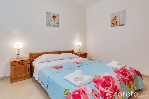 a bedroom with a blue bed with towels on it at Apartmani Niko in Kožino