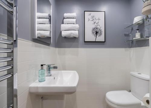 a bathroom with a sink and a toilet and towels at Melrose Guesthouse in Ambleside