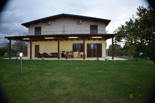 a large white house with a balcony on a yard at Artemis in Mirto Crosia